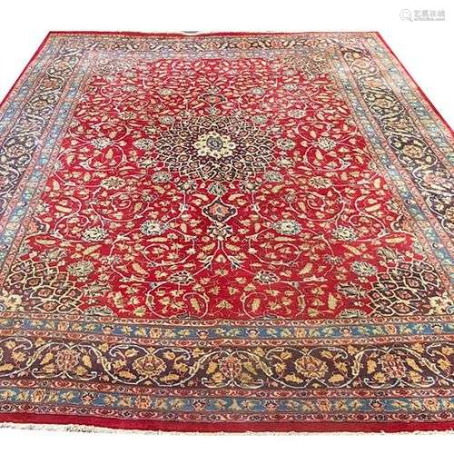 Tapis d Orient à fond rouge à décor floral et centre bleu ra...