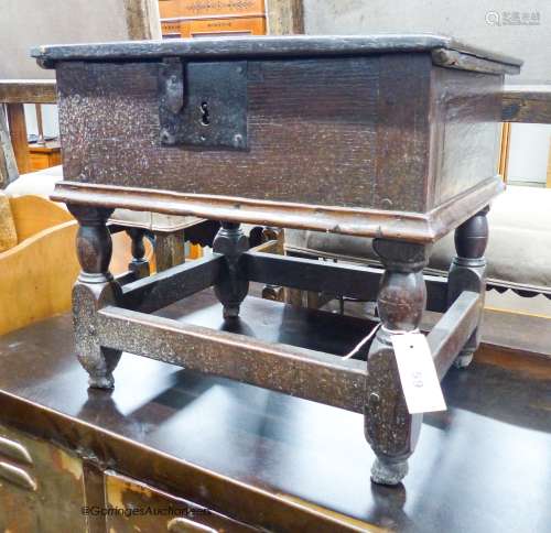 A 17th century oak box stool with hinged rectangular seat, w...