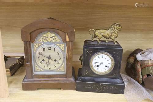 A slate mantel clock with lion surmount and a mahogany mante...