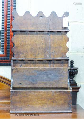 An 18th century oak spoon rack, of shaped outline with lidde...