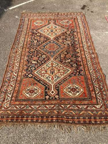 An early 20th century Persian blue ground rug, having three ...