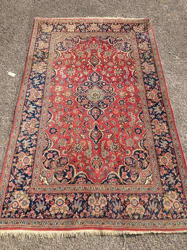 A Kashan red ground rug, with all-over stylised floral motif...