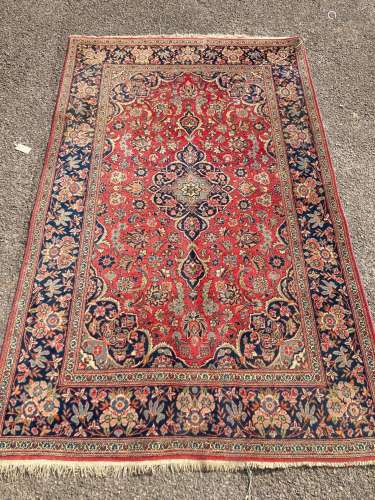 A Kashan red ground rug, with all-over stylised floral motif...