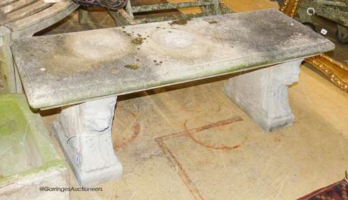 A reconstituted stone bench, with moulded rectangular top on...