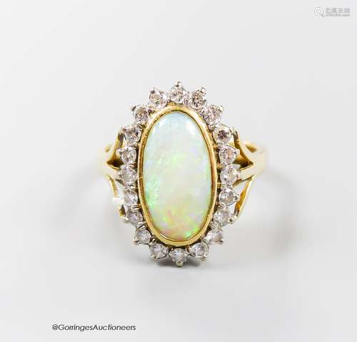 An 18ct, white opal and diamond set oval cluster ring, size ...