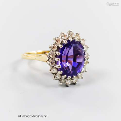 A modern yellow metal, amethyst and diamond set oval cluster...