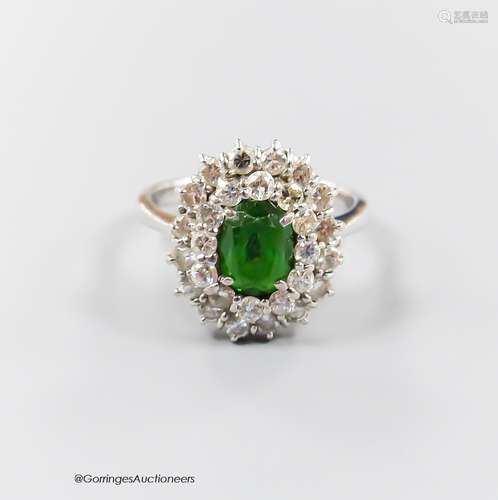 A modern 18ct white gold, green garnet and diamond set oval ...