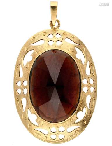 Vintage pendant with garnet in an openwork engraved 14K. yel...