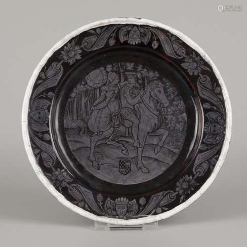 A black and grey enamelled charger depicting an equestrian c...