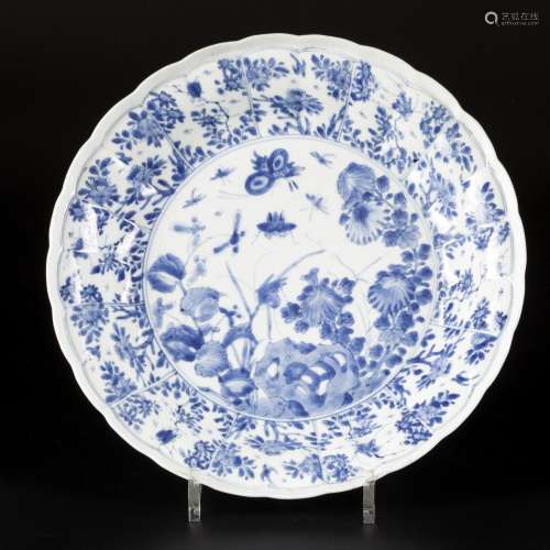 A porcelain charger with floral decoration in sections, with...