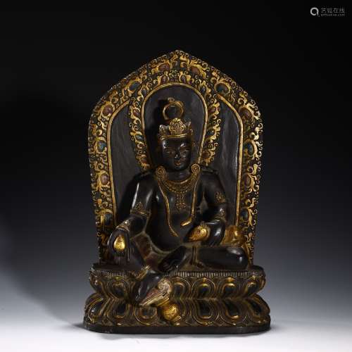 Ancient black stone painted gold Buddha statue