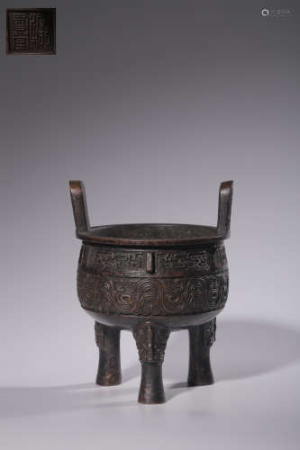 A tripod stove with animal-face motif
