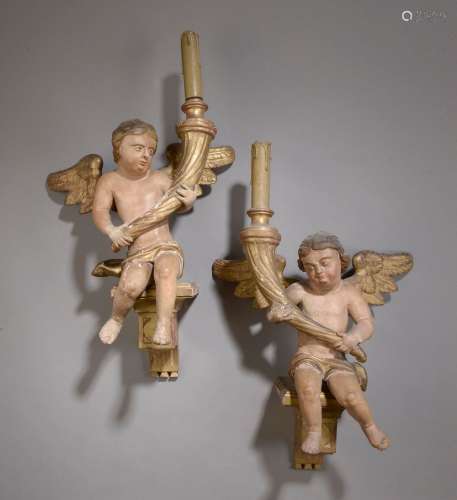 Deux anges en bois sculpé, restuqué et relaqué portant des c...