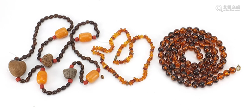 Two amber coloured necklaces and a nut necklace, the