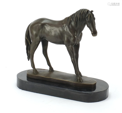 Patinated bronze horse raised on a black...