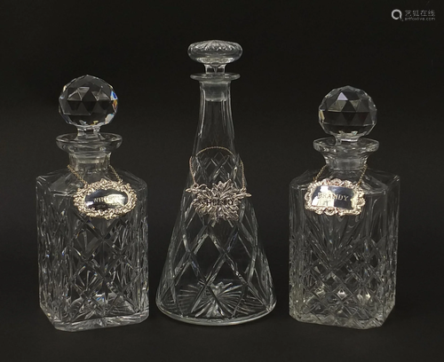 Three cut glass decanters with labels including two