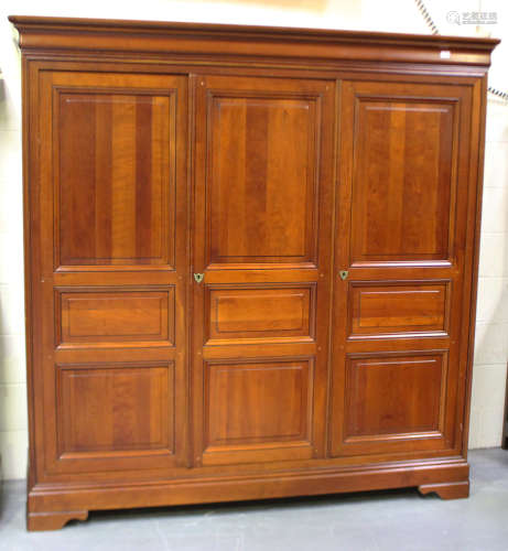A modern cherrywood wardrobe, the moulded pediment above pan...