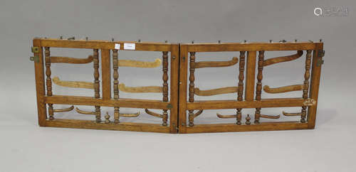 An Edwardian oak folding and hanging coat rack with brass fi...