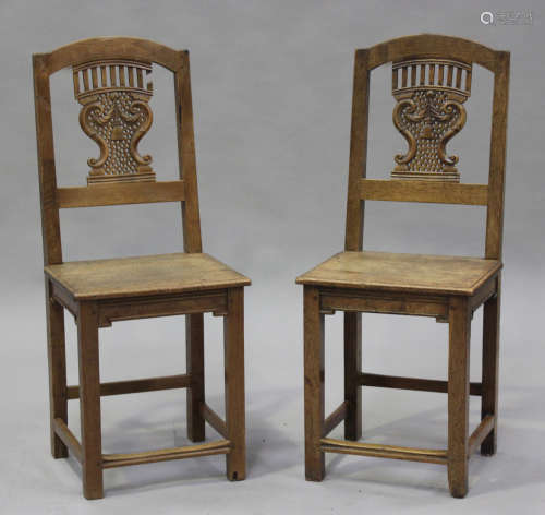 A pair of late 19th century French oak hall chairs with carv...