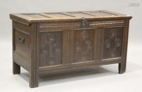 An early 18th century panelled oak coffer with carved decora...