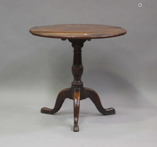 An 18th century oak tip-top circular wine table, on a turned...