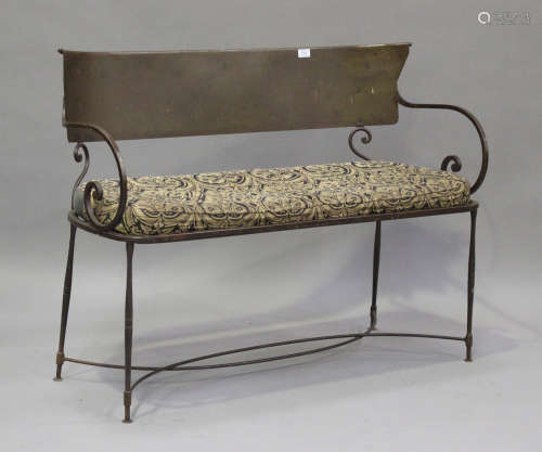 An early 20th century wrought steel bench with carved panel ...