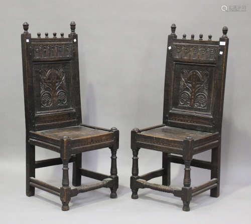 A pair of early 18th century oak panel back hall chairs with...