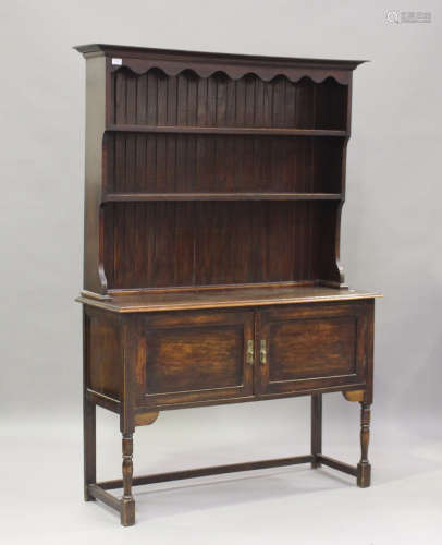 An early 20th century oak dresser, the shelf back above a cu...