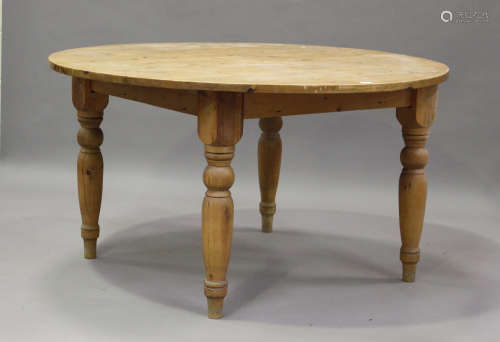 An early 20th century pine circular kitchen table, on turned...