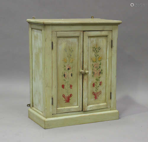 A 20th century painted pine two-door cupboard, on a plinth b...