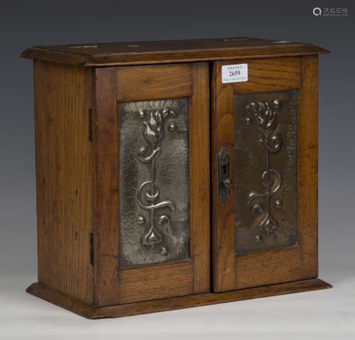 An Edwardian oak smoker's cabinet with inset pressed copper ...