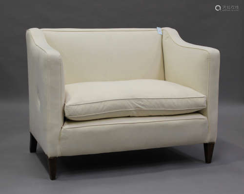 An early 20th century two-seat wing back settee, upholstered...