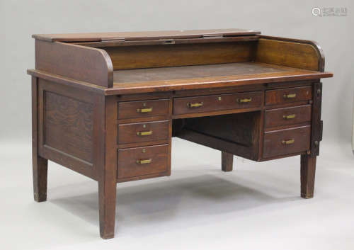 A George V oak roll-top desk, fitted with six drawers, on bl...