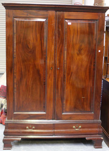 A George V mahogany wardrobe, fitted with a pair of panel do...