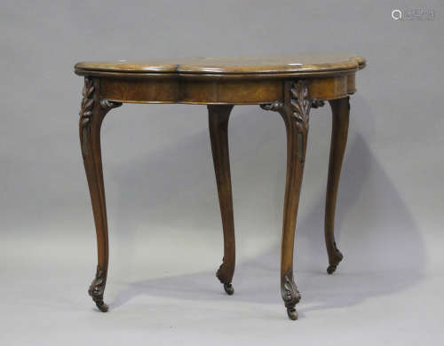 A mid-Victorian walnut fold-over card table with foliate inl...