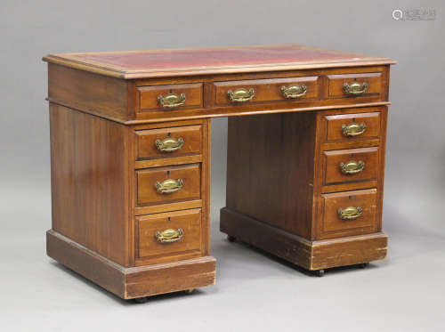 An Edwardian walnut twin pedestal desk, fitted with nine dra...