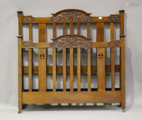 An Edwardian walnut double bed frame with carved foliate dec...