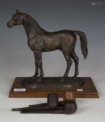 A late 20th century bronzed resin figure of a standing horse...