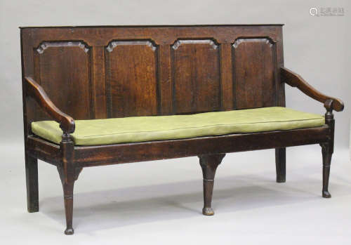 A George III oak settle with four panel back, on turned legs...