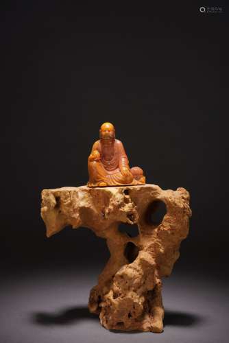 A SOAPSTONE CARVED LUOHAN ON STAND