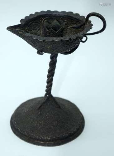 An Islamic heavily embossed metal candle holder 16cm