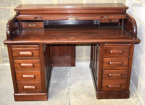 A large wooden American roll top back desk with a tambour fr...