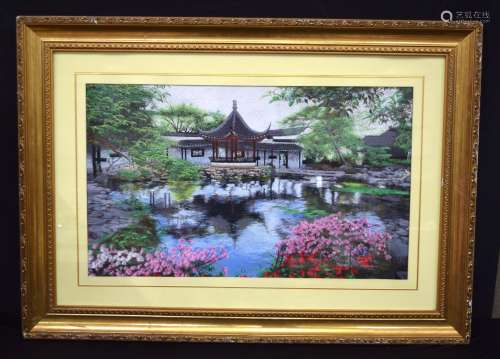 A large framed Japanese silk picture of a property by a lake...