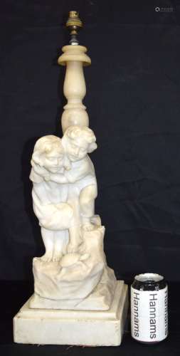 A large carved alabaster lamp stand depicting children playi...
