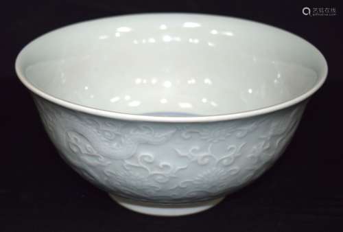 A Chinese porcelain Celadon bowl decorated in relief with dr...