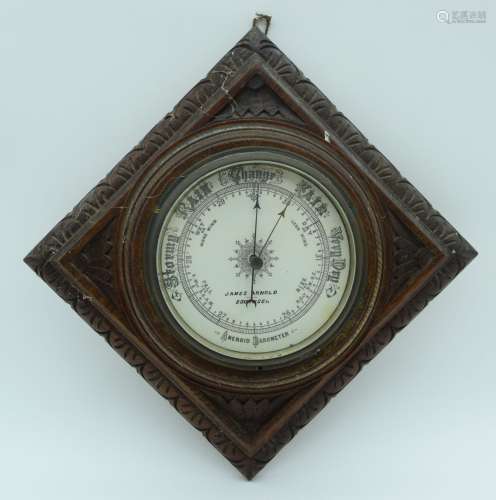 An antique James Arnold aneroid barometer set in a carved wo...