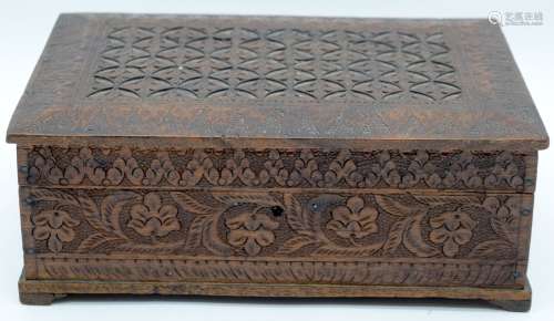 A carved wooden lidded box probably Indian containing some l...