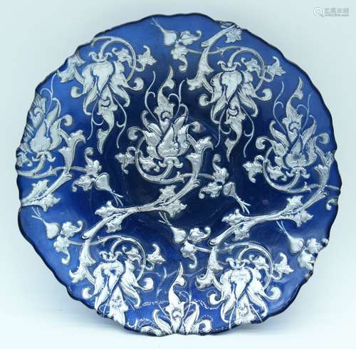 A vintage blue carnival glass dish decorated with silver fol...