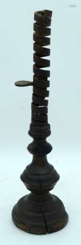 An early iron adjustable candle stick with a wooden base 40c...