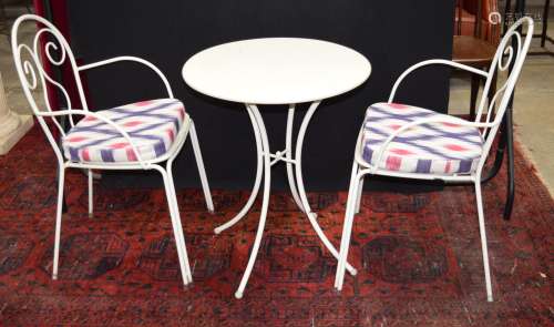 A metal garden table with two chairs with upholstered covers...